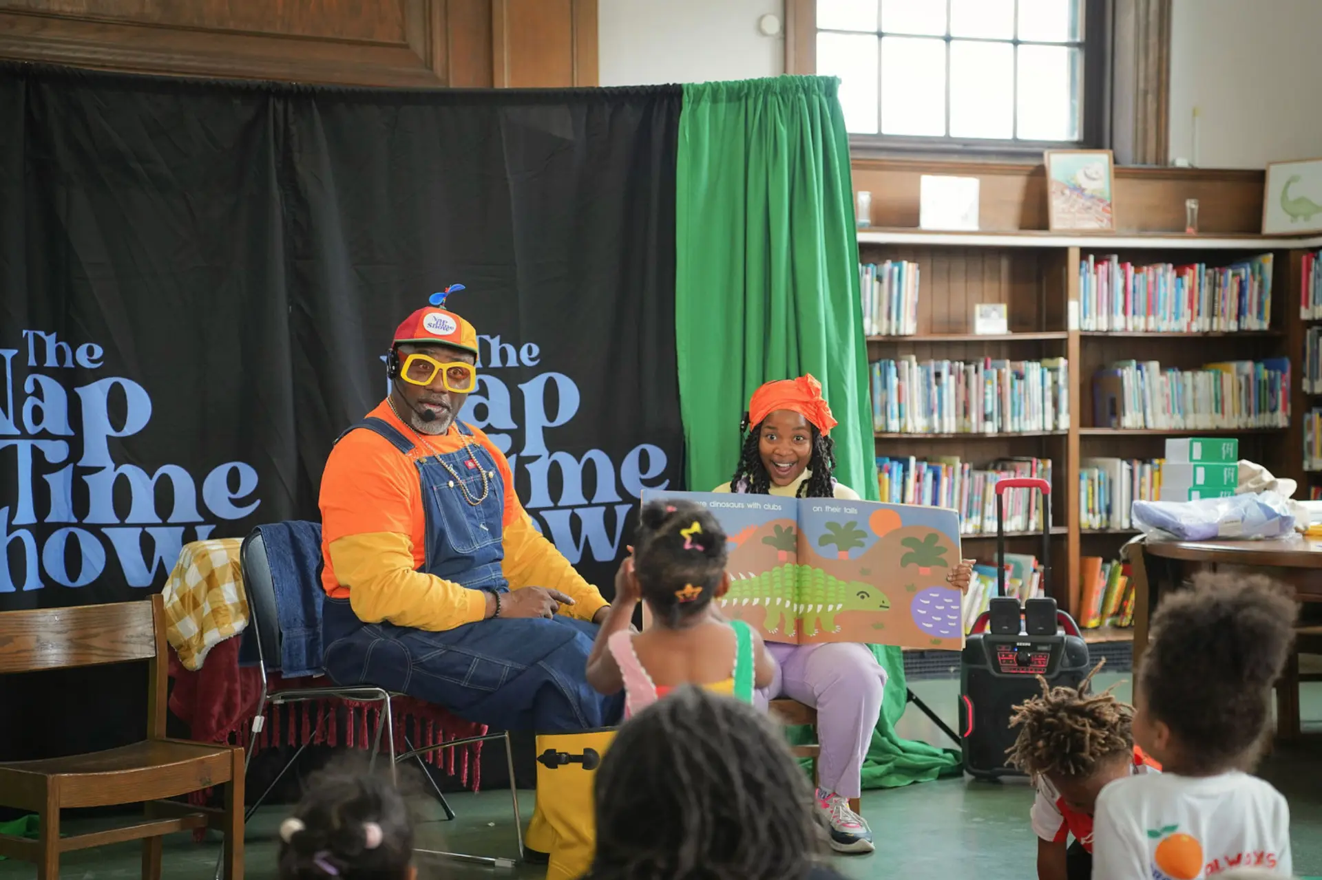 Sierra Boone and Mr. Boots sharing a picture book with children at Duffield Library